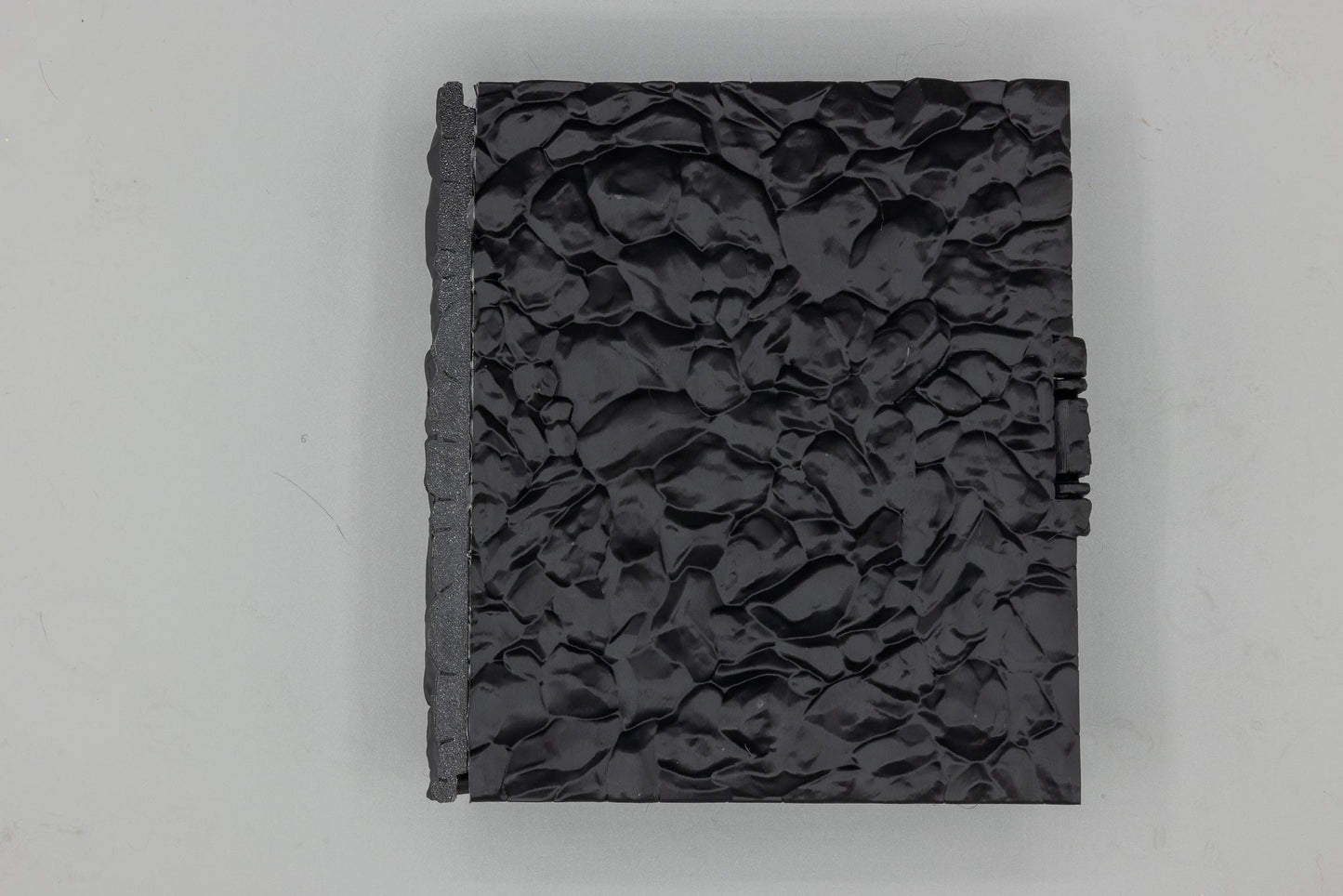 Back cover of the Dragon Dice Book in black PETG dragon-scale texture