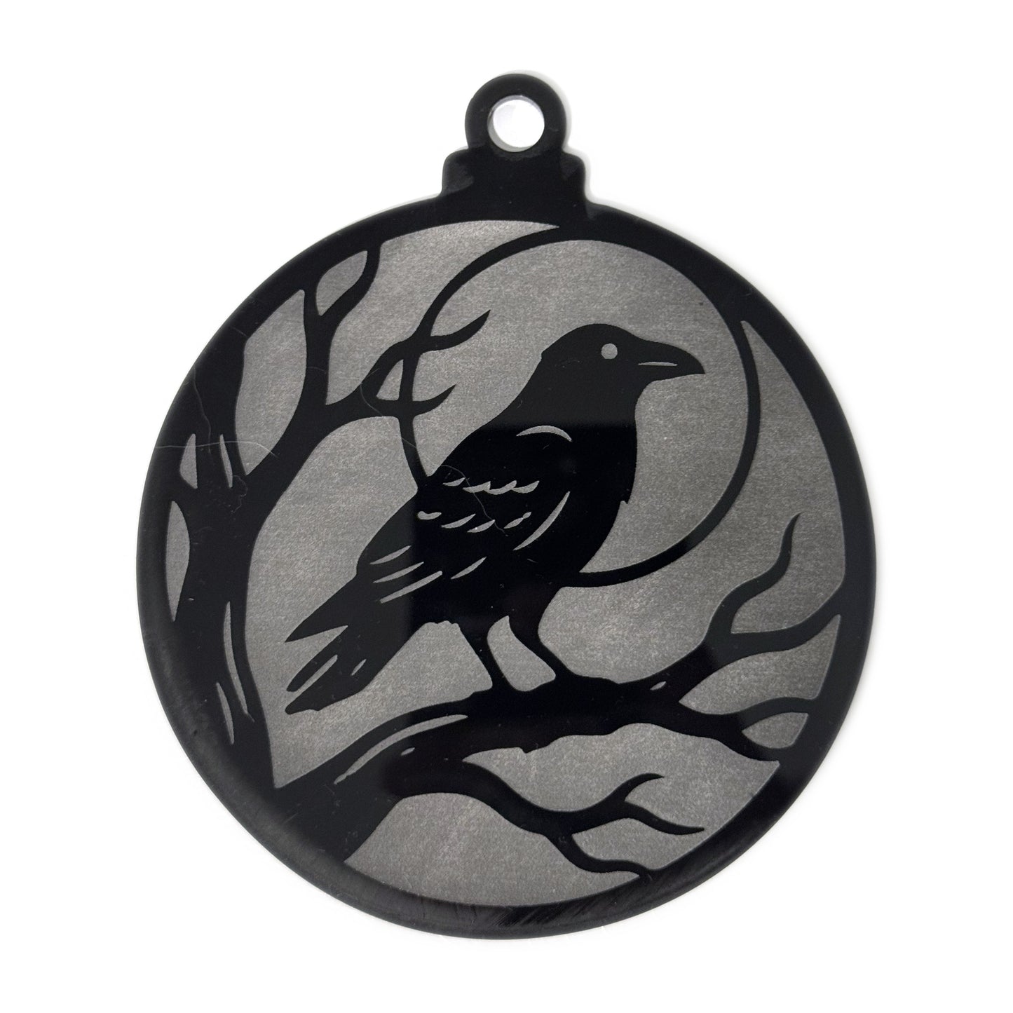Raven Moon Halloween ornament — a raven perched on a bare branch against a full moon, engraved to a frosted grey finish on glossy black acrylic, 4.3 by 5.1 inches with a hanger loop