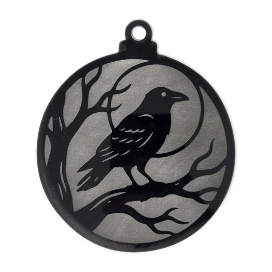 Raven Moon Halloween ornament — a raven perched on a bare branch against a full moon, engraved to a frosted grey finish on glossy black acrylic, 4.3 by 5.1 inches with a hanger loop